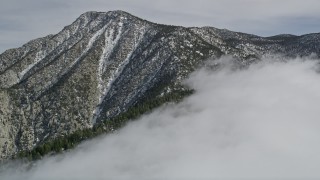 AX0010_095 - 5K aerial stock footage approach a peak with light snow in the San Jacinto Mountains, California