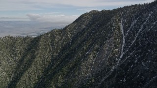 AX0010_102 - 5K aerial stock footage fly over rugged slopes with patches of snow in the San Jacinto Mountains, California