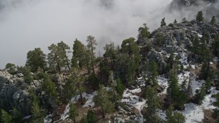 AX0010_118 - 5K aerial stock footage pan across snow and boulders on a San Jacinto Mountains slope in winter, California