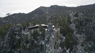 AX0010_119E - 5K aerial stock footage of orbiting a mountaintop tram station in the San Jacinto Mountains with light snow, California