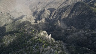 AX0010_121E - 5K aerial stock footage tilt to bird's eye of rugged mountain slope in the San Jacinto Mountains with light snow, California