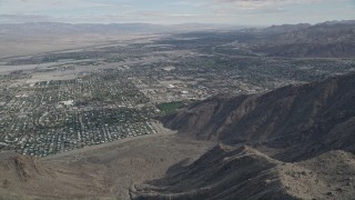 AX0010_127 - 5K aerial stock footage fly over mountain ridge to reveal the North Palm Springs suburban neighborhoods, California