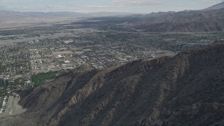 AX0010_128 - 5K aerial stock footage tilt from mountains to reveal suburban neighborhoods in West Palm Springs, California