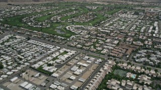 AX0010_131E - 5K aerial stock footage fly over West Palm Springs neighborhoods and tilt to reveal and orbit golf course, California