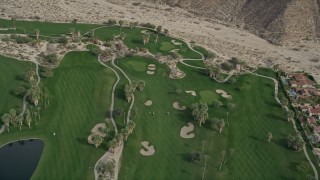 AX0010_134 - 5K aerial stock footage fly over a road and golf course in West Palm Springs, California