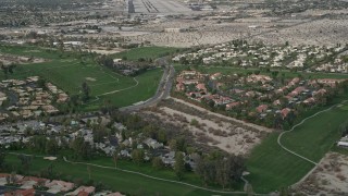 AX0010_140 - 5K aerial stock footage orbit suburban neighborhoods and golf course in South Palm Springs, California