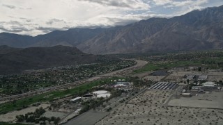 AX0010_143 - 5K aerial stock footage orbit suburban neighborhoods near mountain range in West Palm Springs, California