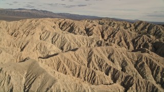 AX0011_005 - 5K aerial stock footage fly over and orbit arid desert mountains in the Mojave Desert, California
