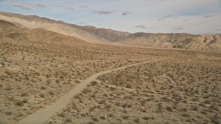 AX0011_011 - 5K stock footage aerial video approach and orbit a lonely dirt road in Joshua Tree National Park, California