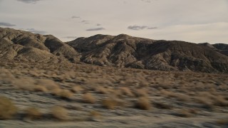 AX0011_014 - 5K aerial stock footage fly low altitude by rugged desert mountains in Joshua Tree National Park, California