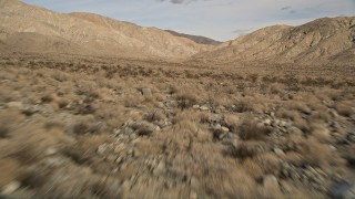 AX0011_015 - 5K aerial stock footage of low altitude approach to desert mountains in Joshua Tree National Park, California
