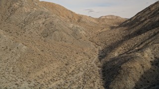 AX0011_018E - 5K aerial stock footage of a canyon between desert mountains in Joshua Tree National Park, California