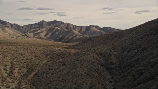 AX0011_020 - 5K aerial stock footage of flying by desert mountains in Joshua Tree National Park, California