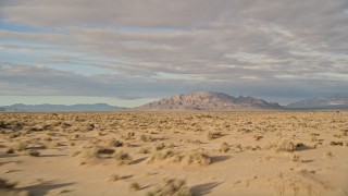 AX0012_001 - 5K stock footage aerial video fly low over desert toward mountains, Mojave Desert, California