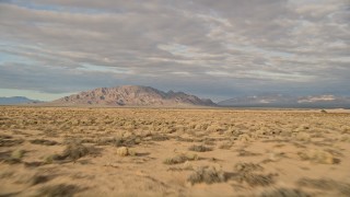 AX0012_003 - 5K aerial stock footage fly over desert vegetation toward mountains, Mojave Desert, California