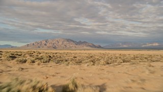 AX0012_004 - 5K stock footage aerial video fly over desert vegetation toward mountains, Mojave Desert, California