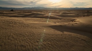 AX0012_037 - 5K stock footage aerial video of flying over sand dunes to open desert, Kelso Dunes, Mojave Desert, California