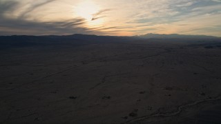 AX0012_051 - 5K aerial stock footage of a desert plain, Mojave Desert, California, sunset