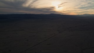 AX0012_053 - 5K aerial stock footage of Mojave Desert plain at sunset in California