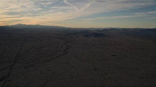 AX0012_055 - 5K stock footage aerial video of a flat desert plain at sunset in the Mojave Desert, California