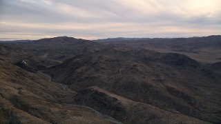 AX0012_058 - 5K aerial stock footage fly by desert mountains, Mojave Desert, California, sunset