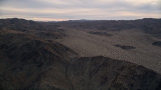 AX0012_059 - 5K aerial stock footage fly by desert mountains, Mojave Desert, California, sunset