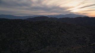 AX0012_060 - 5K aerial stock footage fly over desert mountains, Mojave Desert, California, sunset