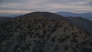 AX0012_061 - 5K aerial stock footage orbiting desert summit peaks, Mojave Desert, California