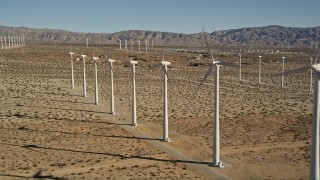 AX0013_014E - 5K aerial stock footage of flying by windmills in the desert, San Gorgonio Pass Wind Farm, California