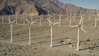 AX0013_020E - 5K aerial stock footage of flying by rows of windmills, San Gorgonio Pass Wind Farm, California