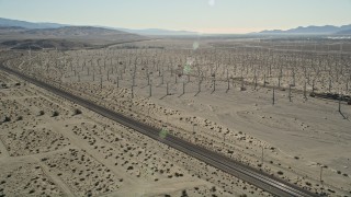 AX0013_026E - 5K stock footage aerial video fly over windmills, orbit railroad tracks, San Gorgonio Pass Wind Farm, California