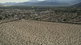 AX0013_032 - 5K aerial stock footage tilt up from desert revealing residential neighborhoods, North Palm Springs, California