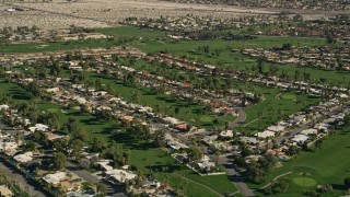 AX0013_053E - 5K aerial stock footage video of residential neighborhoods and golf course, West Palm Springs, California