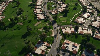 AX0013_065E - 5K aerial stock footage of condominiums among a golf course, Rancho Mirage, California