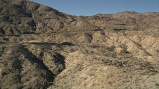 AX0014_002 - 5K aerial stock footage approach a mountain peak revealing a highway, San Jacinto Mountains, California