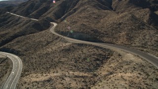 AX0014_003 - 5K aerial stock footage approach a highway through San Jacinto Mountains, California