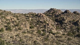 AX0014_009 - 5K aerial stock footage fly over stony mountains revealing Caochella Valley, San Jacinto Mountains, California