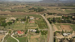 AX0014_056 - 5K aerial stock footage fly over rural homes and vineyards, Temecula, California