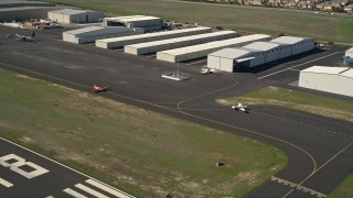 AX0014_068 - 5K aerial stock footage of tracking small planes on a runway, French Valley Airport, Temecula, California