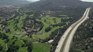 AX0015_001 - 5K aerial stock footage follow Interstate by golf course and hills, Temecula, California