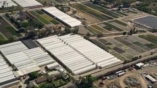 AX0015_010 - 5K aerial stock footage of farmland and greenhouses, Fallbrook, California