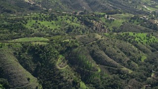 AX0015_015 - 5K aerial stock footage of flying over hills toward farmland, Fallbrook, California