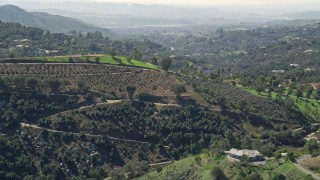 AX0015_019 - 5K aerial stock footage approach farmland and homes on hills, Fallbrook, California
