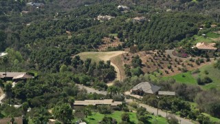 AX0015_020 - 5K aerial stock footage of rural homes among trees, Fallbrook, California