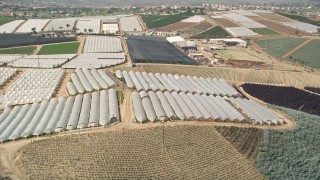 AX0015_036E - 5K aerial stock footage fly over farmland and greenhouses, Fallbrook, California