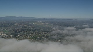 AX0016_007 - 5K aerial stock footage pan across cloud cover to reveal suburban neighborhoods in Oceanside, California