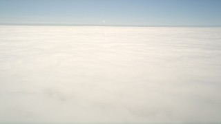 AX0016_008 - 5K aerial stock footage of a reverse view of the edge of the clouds, then pan across the cloud layer, Oceanside, California