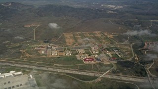 AX0016_024 - 5K aerial stock footage flyby clouds hanging over Camp Pendleton South buildings, California