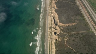 AX0016_029 - 5K aerial stock footage of a bird's eye view of coastal cliffs and empty beach in Oceanside, California