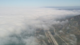 AX0016_032 - 5K aerial stock footage tilt from empty beach and I-5 to reveal heavy cloud cover, Oceanside, California